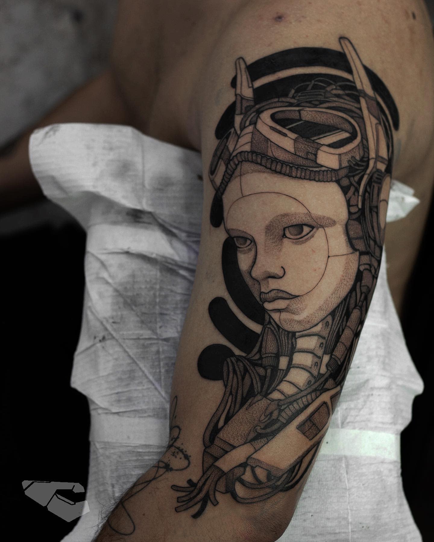 A detailed tattoo of a female cyborg with a helmet and intricate machinery around her